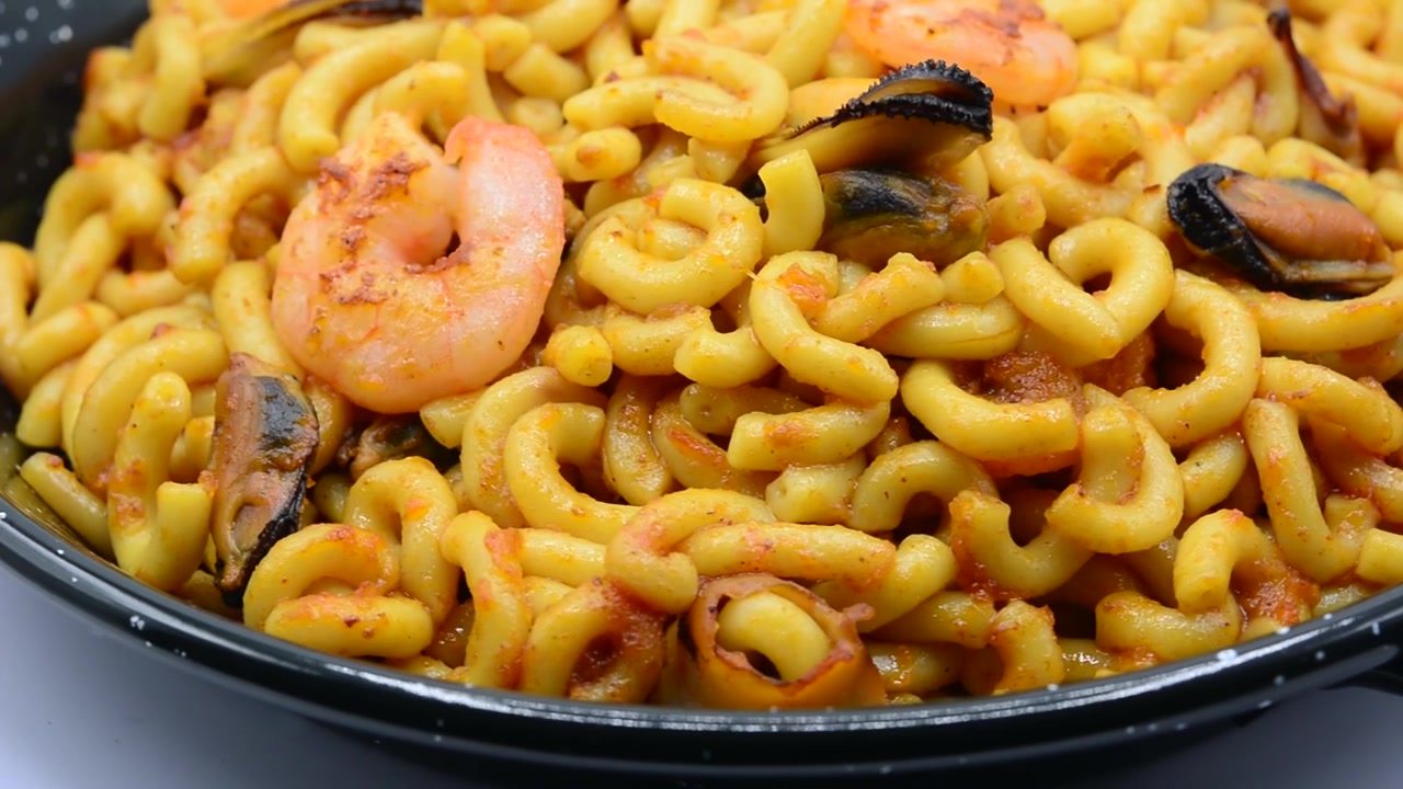 Primo piano di Fideuà con gamberi e cozze in padella