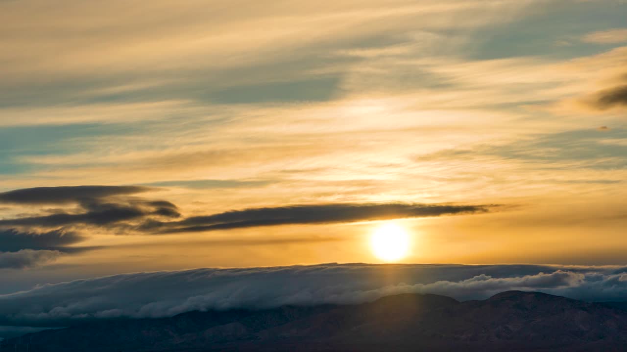 Il cielo dorato e il paesaggio di nuvole offrono una vista suggestiva nel time-lapse in rapido movimento al tramonto