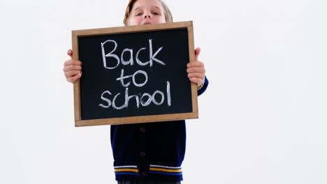 schoolboy holding chalkboard with back to school text