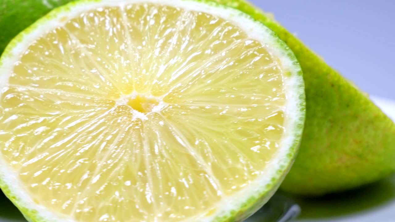 una rebanada de limón verde está girando lentamente en el estudio con los detalles.