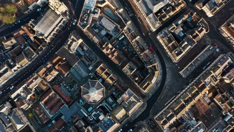 Top-down-drone-shot-of-old-building-blocks-and-streets-in-Bath-city-centre-UK