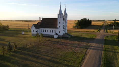 aerial shot of roman catholic church in north american prairie during sunset