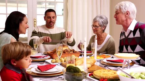 Familia-De-Tres-Generaciones-Cenando-Juntos-De-Navidad