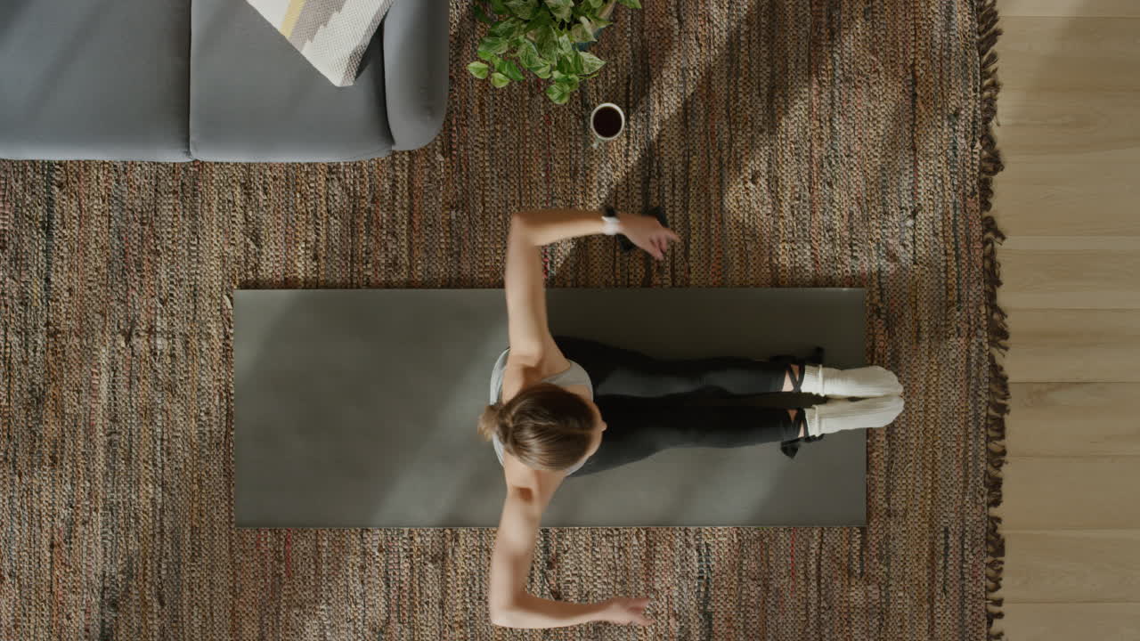 vista superior de una mujer de yoga practicando una pose de curvatura hacia adelante sentada ejerciendo un estilo de vida saludable en casa sobre una colchoneta de ejercicios disfrutando de la meditación de atención plena.