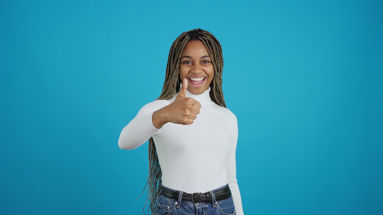 Young Woman Giving Thumbs Up on Blue Background