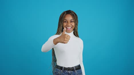 young woman giving thumbs up on blue background