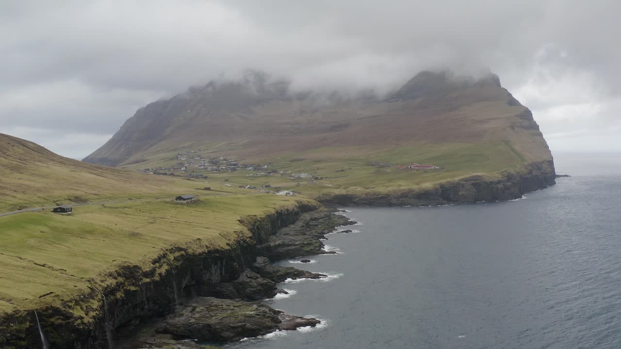 Aerial backwards shot of Enniberg mountain on Vi&eth;oy island during cloudy day