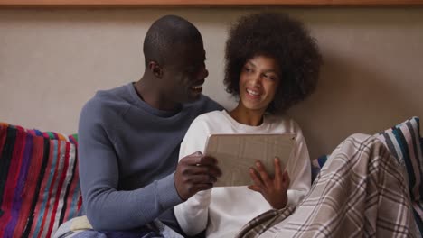 couple using digital tablet in living room