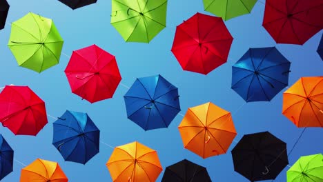 Malta,-Zabbar,-umbrella-street,-spinning-under-the-umbrellas-with-clear-blue-sky-in-the-back