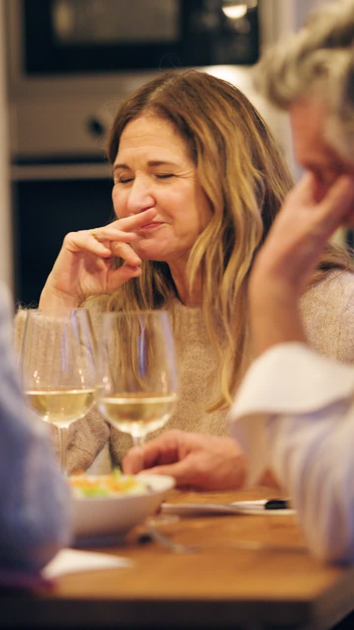 Donna matura che mangia un'oliva e parla a una cena