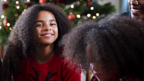 Excited-Children-Sit-On-Floor-With-Mother-As-Family-Celebrate-Christmas-Together