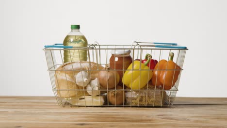 studio shot of basic food items in supermarket wire shopping basket 15