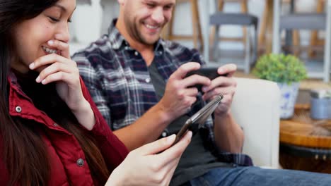 pareja feliz usando teléfono móvil y tableta digital 4k