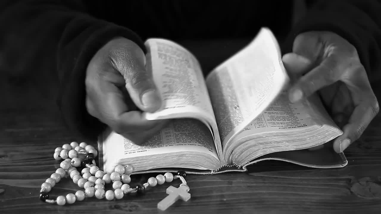 Beten zu Gott mit zusammengelegten Händen auf einer Bibel, mit Menschen und weißem Hintergrund, Stock-Video.