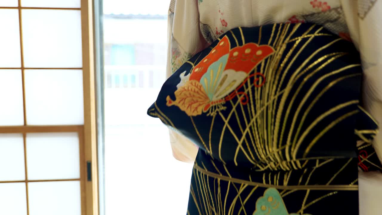 A Woman Putting on a Traditional Japanese Kimono for a Woman in an Old Traditional Japanese House