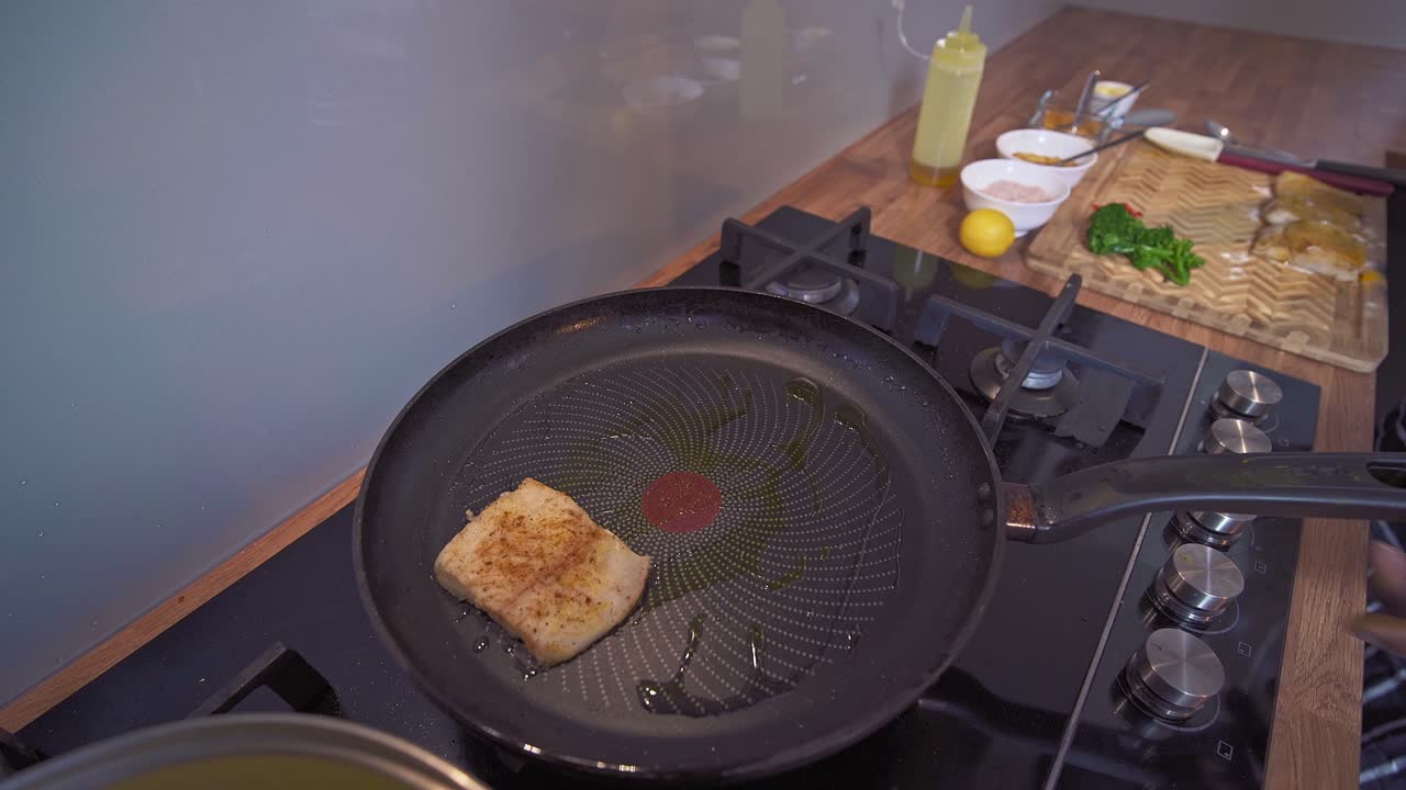 um chef caribenho a assar peixe num fogão.