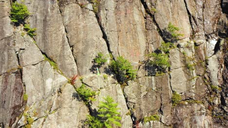 aerial footage push in on lone climber on cliff in maine