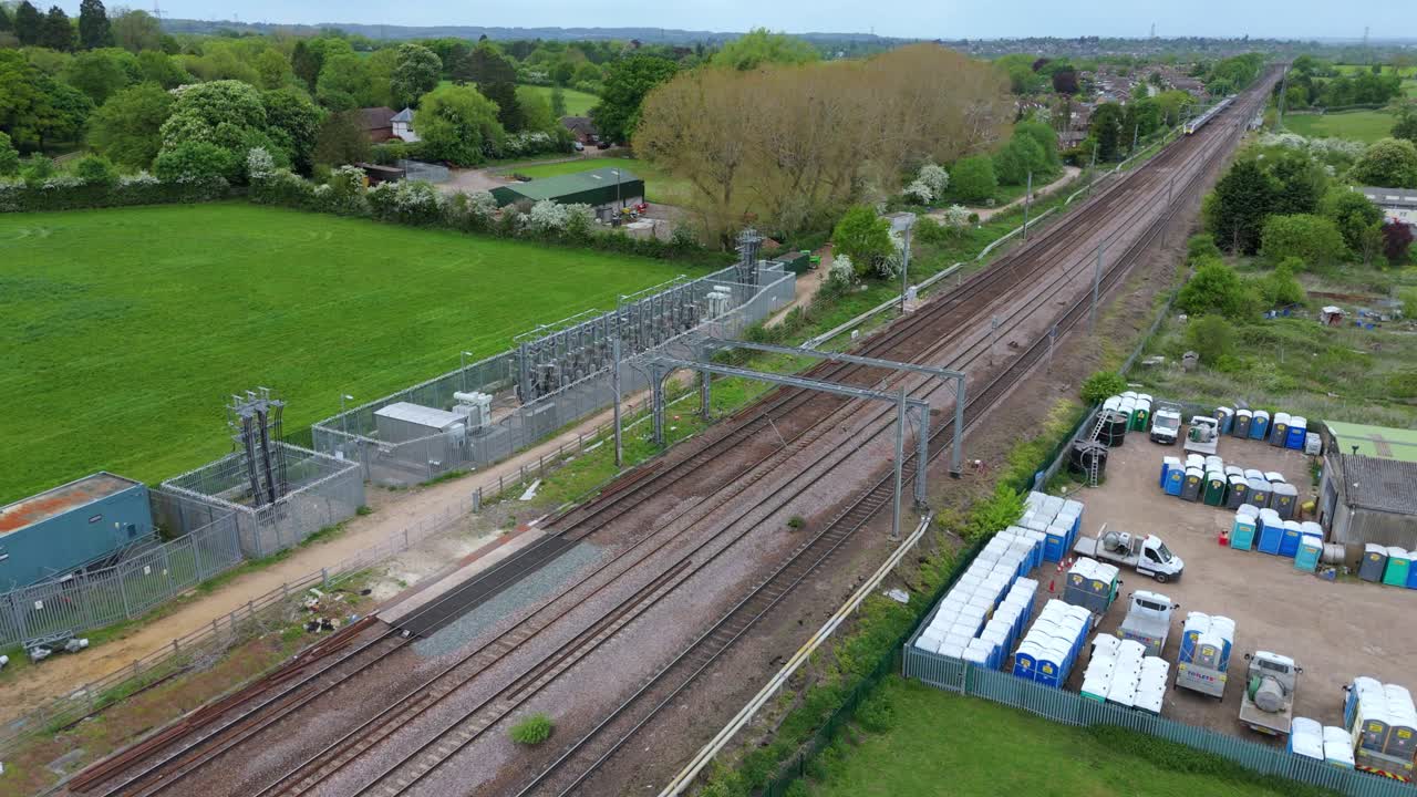 Close Aerial Drone Shot of Train Passing Substation in Hitchin, UK