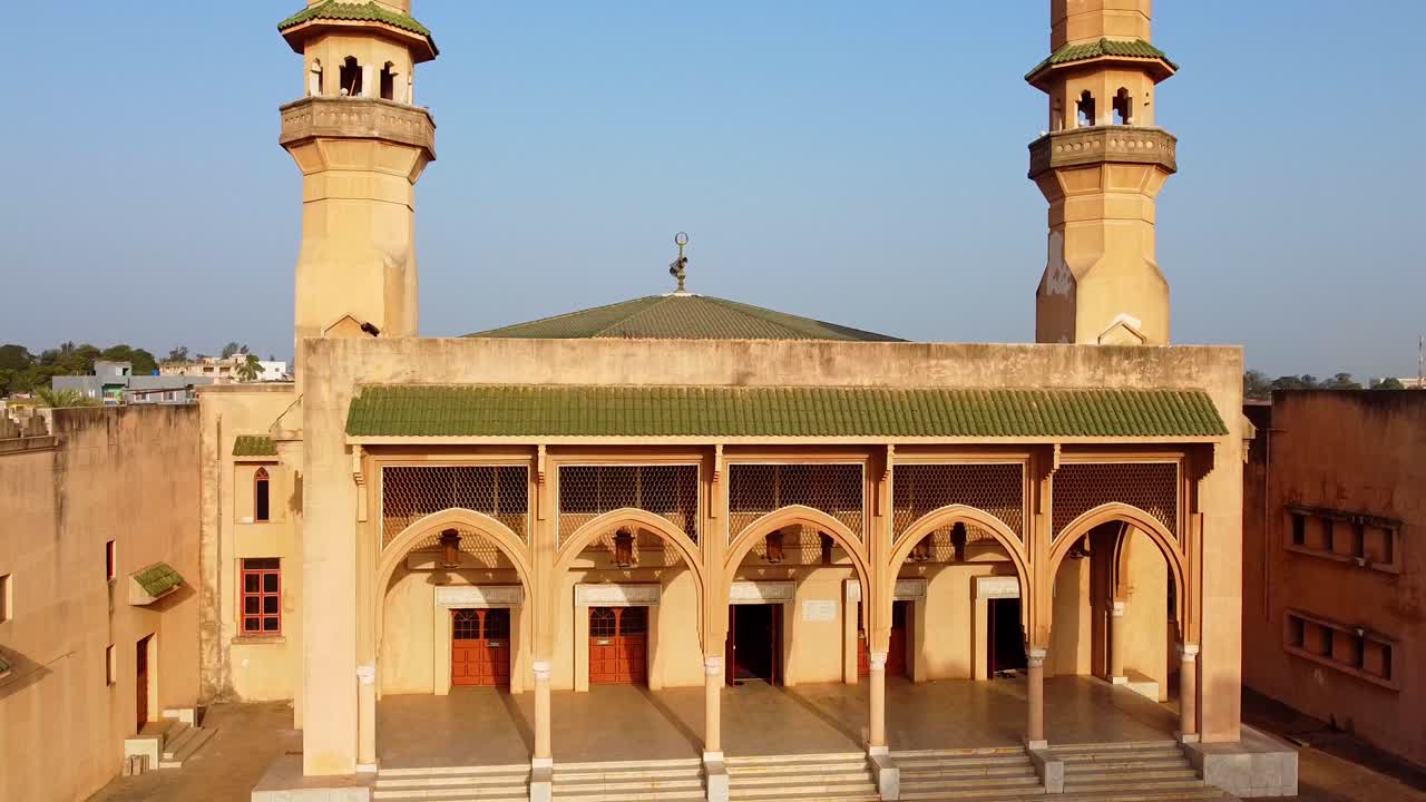 Dynamic aerial view of beautiful mosque facade during golden hour showcasing Islamic architectural details