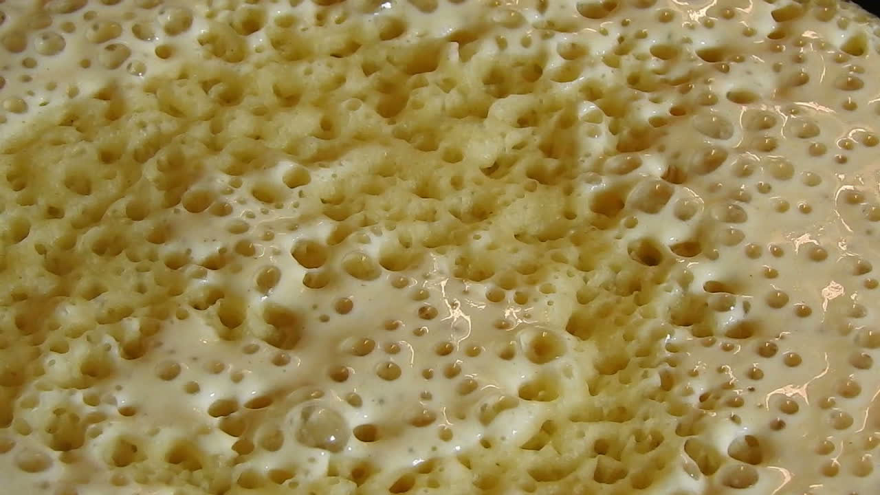 toma de comida de algún baghrer marroquí tradicional casero en freidora de arcilla, panqueques baghrir o crapes con 1000 agujeros
