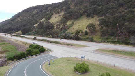 vista aérea de una intersección entre una autopista de 4 carriles y una zona de descanso cerca de un lago