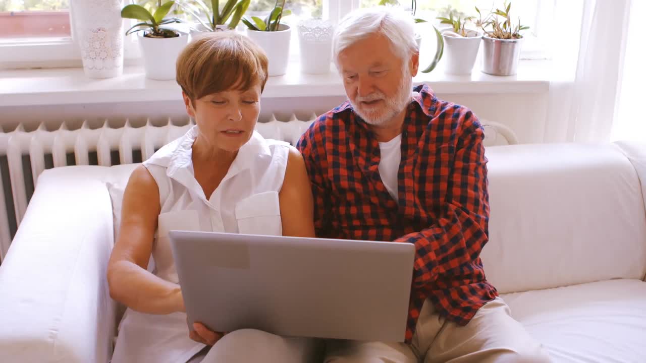 Senior couple laptop in living room