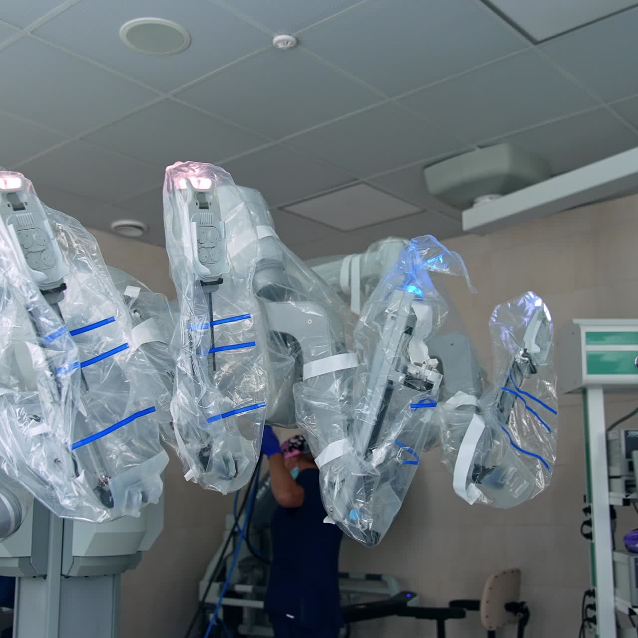 Da Vinci robotic equipment covered with plastic. Two medical workers preparing equipment for usage during operation