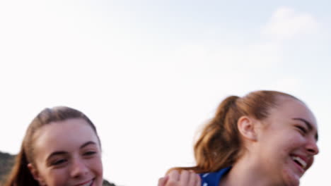 Portrait-Of-Female-High-School-Soccer-Team-Running-Towards-Camera-And-Celebrating