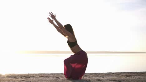 woman in yoga outfit doing yoga on a beach and in front of the water. mix of poses. yoga pose - cobra. meditation. asana - bhujangasana