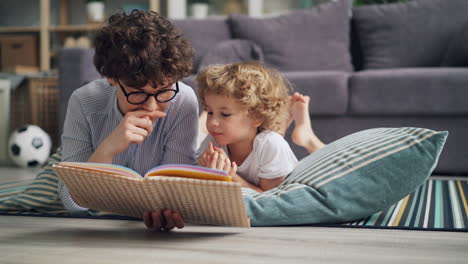 mother and son reading a book together on the floor