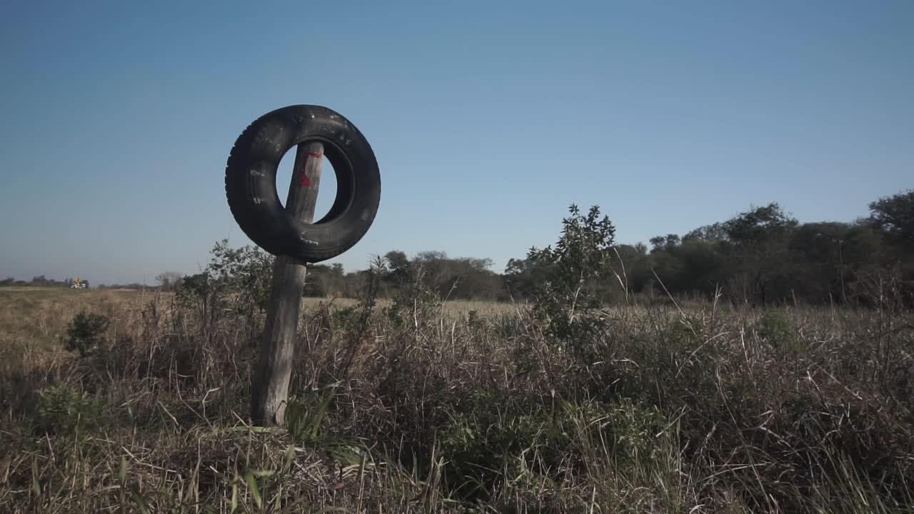 toma estática de un neumático colocado en un poste de madera como señal de entrada a la granja, argentina