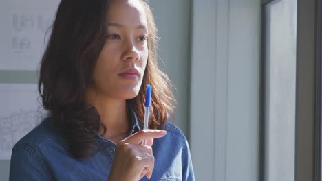 Businesswoman-looking-away-in-modern-office