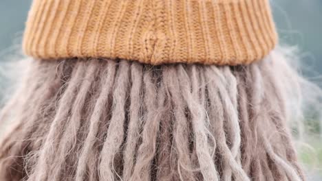 man with dreadlocks wearing an orange knitted beanie