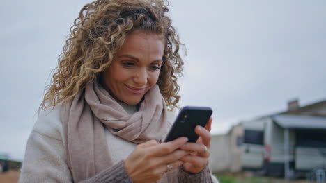 positive lady messaging mobile phone on cloudy nature close up. smiling woman