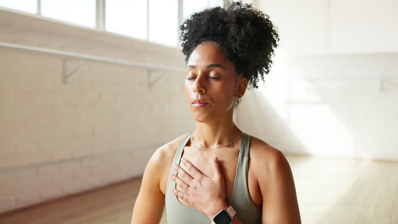 Woman Meditating with Hand on Chest in Yoga Studio