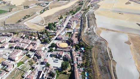 Plaza-De-Toros-De-Tiro-Fijo-Aéreo-Plaza-De-Toros-Rodeada-De-Casas-Antiguas-Tradicionales-Y-Prados-Secos