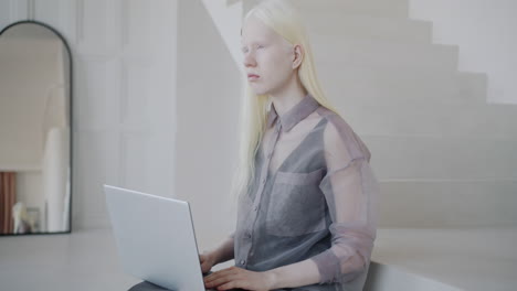 woman working on laptop on stairs