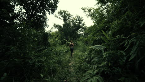 woman hiking through lush tropical forest