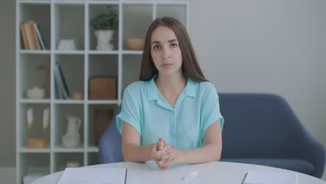 The-woman-listens-while-looking-at-the-camera-and-nods-her-head-approvingly.-Participant-in-the-video-call-dialog.-Video-conference-listener-sitting-at-home