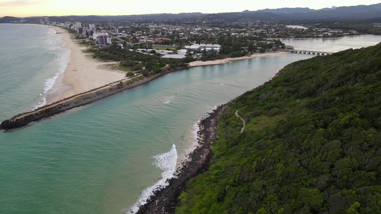 bosque verde en la colina de burleigh y el espigón rocoso en la playa de burleigh en la costa dorada, australia