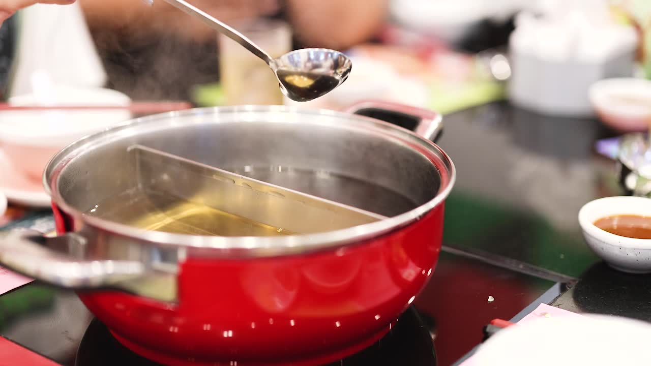 Preparing hotpot soup with ladle and pot