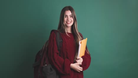 happy young woman student standing with books
