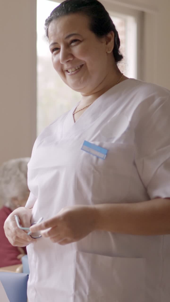 Happy caregiver smiling at camera in geriatric