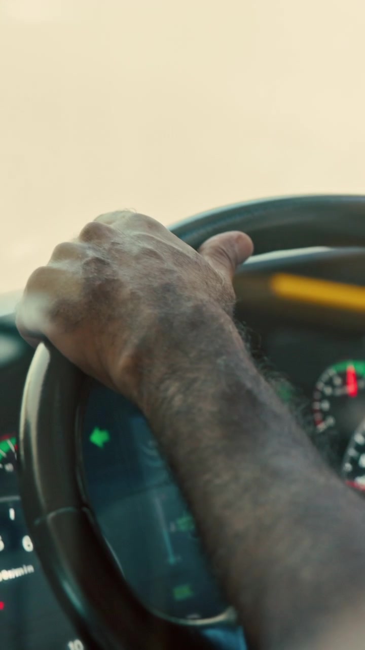 Close-up of a Man's Hand Steering a Vehicle