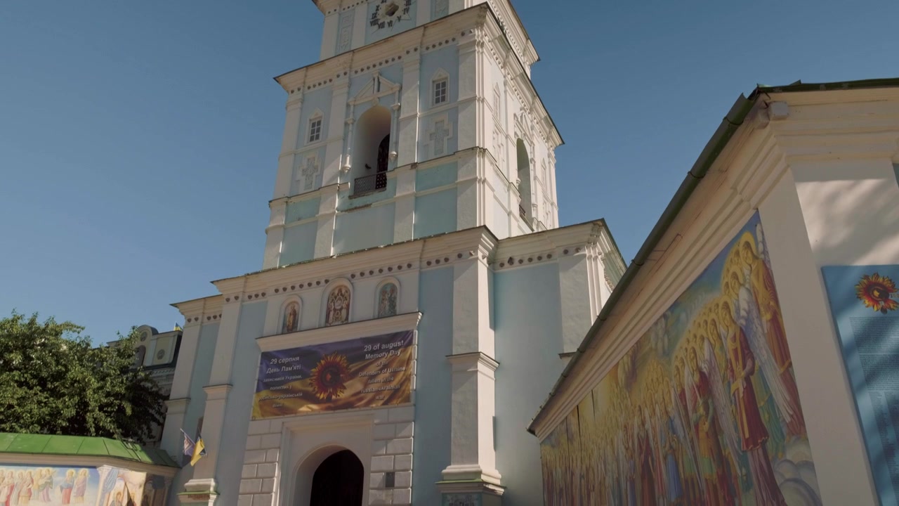 Lenta panoramica verso il basso della torre del Monastero di San Michele dalle cupole d'oro a Kiev in una soleggiata giornata autunnale.