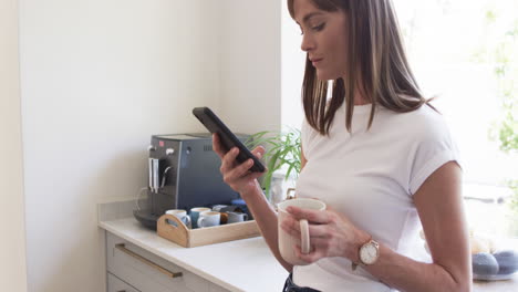 middle-aged caucasian woman checks her phone at home, with copy space