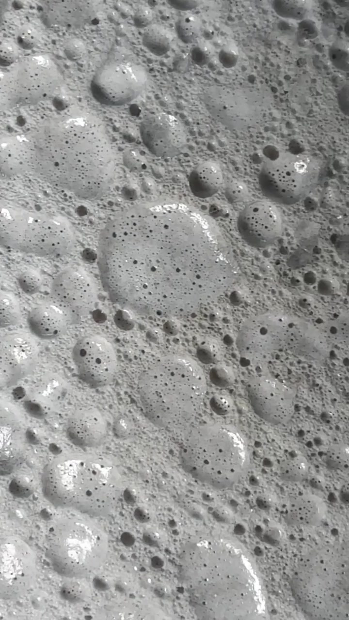 Primo piano di bolle di sapone in movimento su una superficie liquida
