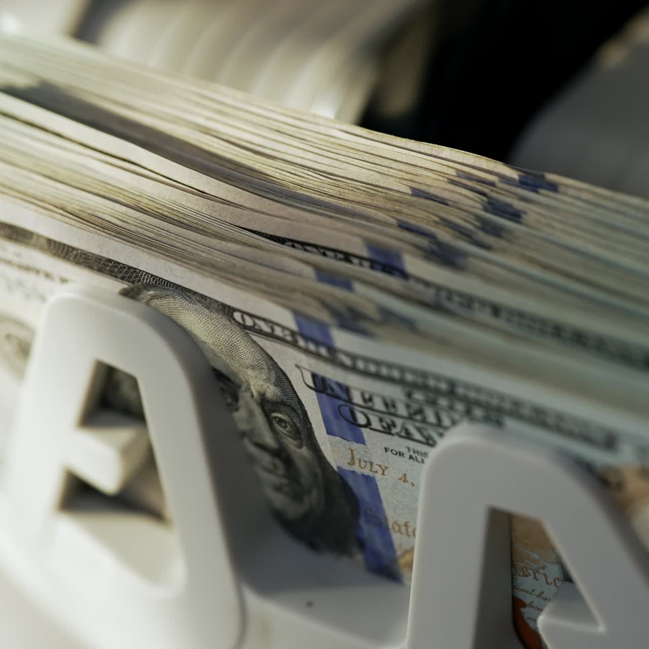 Rotating mechanism of cash machine turning money. One hundred dollar bills being counted in electronic device. Close up