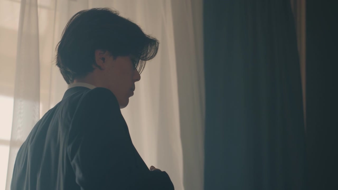 年輕白人男子拿起外套和公事包，陽光普照的房間，穿上外套並背起包包，邁著堅定步伐走向門口，展現商務人士的活力，都市通勤氛圍，微妙的陰影與對比，充滿電影感。