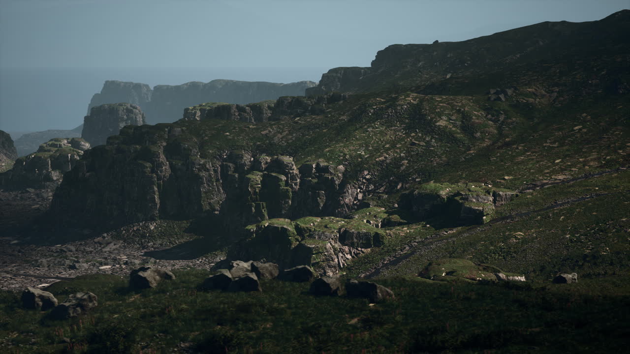 잔디로 인 언덕과 절벽이 있는 웅장한 산맥